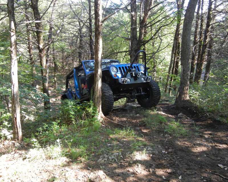 blue jeep cresting hill