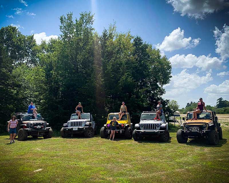 Jeeps with women sitting on the hoods
