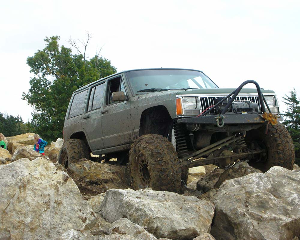 Jeep driving over large boulders